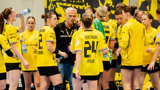 Kay Rothenpieler hält eine Ansprache im Kreis seiner Spielerinnen