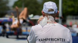 Ein Kampfrichter beim Mehrkampf-Meeting in Ratingen kühlt sich mit einem Eisbeutel