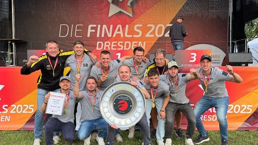 Dirk Schachtsiek jubelt gemeinsam mit seinem Team.