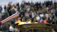 Die Olympische Fackel wird angezündet