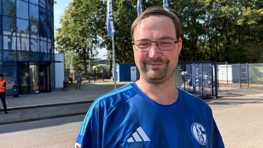 Schalke-Fan Dominic Kuhn steht vor dem Fanshop von Schalke 04