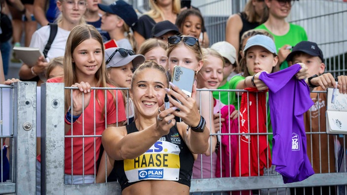 Sprint-Star Rebekka Haase macht ein Selfie mit Fans