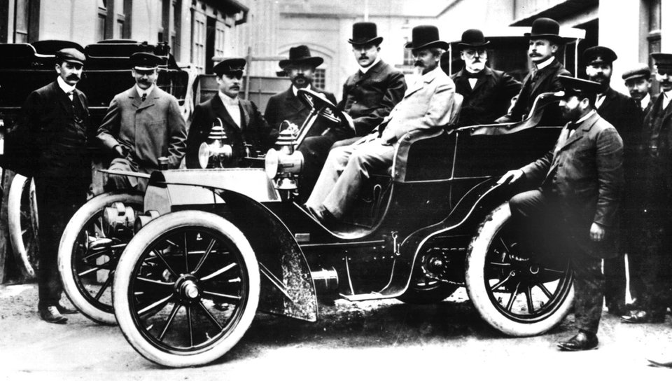 Der Autopionier Wilhelm Maybach sitzt auf dem Beifahrersitz eines Mercedes-Simplex-Wagens aus dem Jahre 1903 