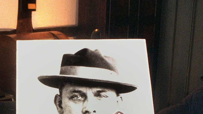 Das vermutliche originale Beil des Massenmörders vor seinem Portrait