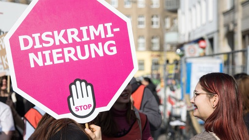 "Diskriminierung Stop" steht auf dem Schild einer Teilnehmerin auf einer Demonstration.