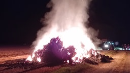 Brennende Strohballen auf einem Feld