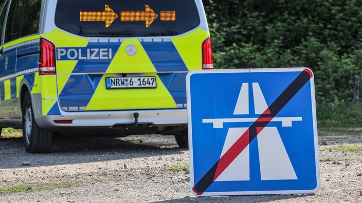 Ein Hinweisschild für eine gesperrte Autobahn steht beim Eigensicherungstag der Polizei Nordrhein-Westfalen vor einem Einsatzfahrzeug.