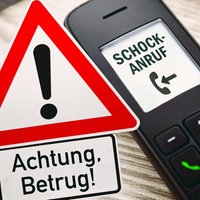 Telefon mit der Aufschrift "Schock-Anruf", daneben ein auffälliges Warndreieck "Achtung, Betrug!"