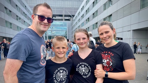 Familie lächelt in die Kamera und trägt T-shirts von den Toten Hosen 
