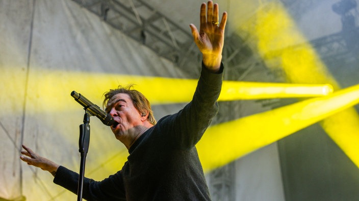 Sänger der Toten Hosen, Campino, steht auf einer Bühne und singt