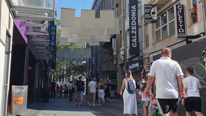 Tücher hängen über der Einkaufsstraße Hohe Straße in Köln