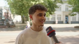 Eine Person steht draußen und spricht in ein Mikrofon