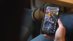 Handy, auf dem TikTok geöffnet ist, Kallies mach Foto mit einem Fan.