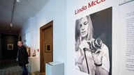 Bild von Linda McCartney mit Kamera in der Hand auf einem Foto in einer Fotoausstellung