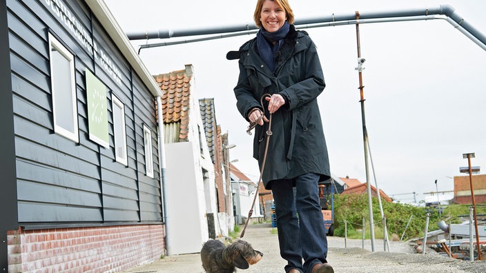 Bettina Böttinger in ihrer zweiten Heimat: in Zeeland/NL auf dem Weg zur Austernzucht im Hafen Yerseke mit ihrem Rauhhaardackel Finchen.