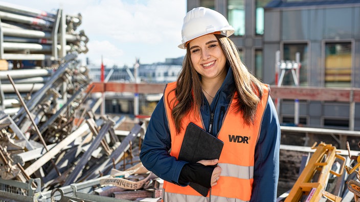 Junge Architektin mit Schutzhelm auf Baustelle