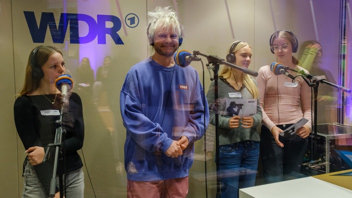 Moderator und DJ Jan-Christian Zeller mit Schülerinnen im Hörfunk-Studio.