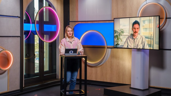 Moderatorin Janina Werner im Studio mit zugeschaltetem Korrespondenten