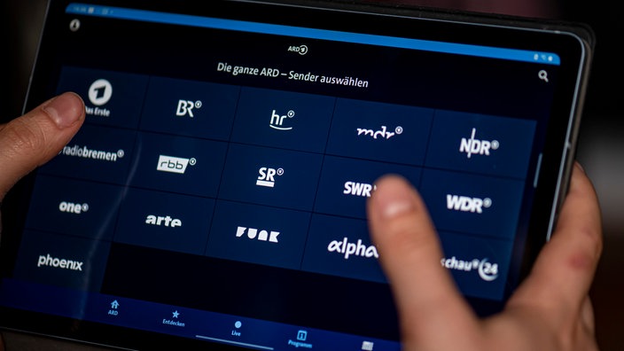 Ein Mann benutzt die ARD-Mediathek App auf einem Tablet