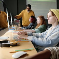 Schüler an PC, gelbe Mütze
