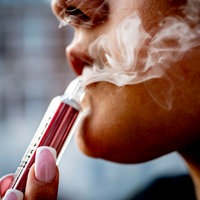 Eine junge Frau raucht eine Vape 