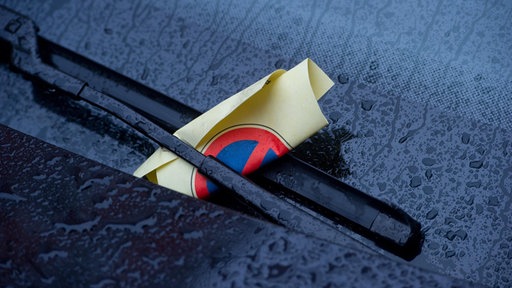 Windschutzscheibe mit Strafzettel hinter dem Scheibenwischer