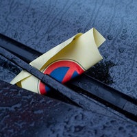 Windschutzscheibe mit Strafzettel hinter dem Scheibenwischer
