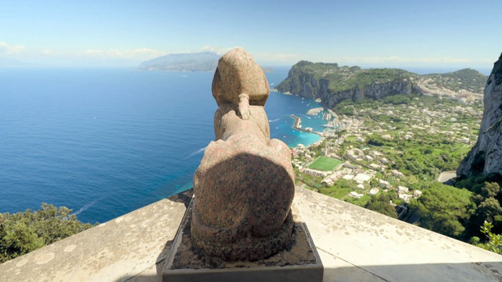 Blick über die steinerne Sphinx auf die tief darunter liegende Bucht