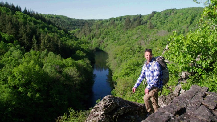 Ramon Babazadeh steht zwischen Felsen hoch über dem Ourthe-Tal