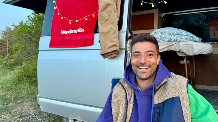 Ramon Babazadeh steht vor seinem Campervan
