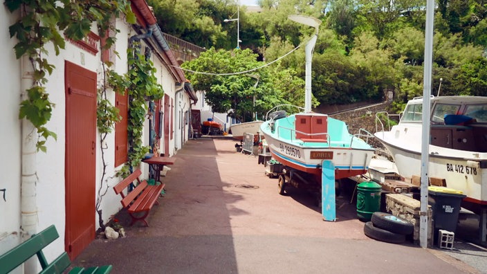 Kleine Fischerhütten, vor denen Boote aufgebockt sind