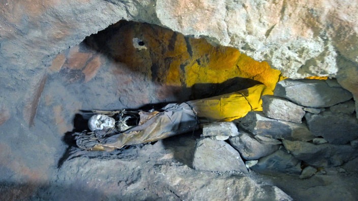 Blick auf eine Mumie in einer Gesteinshöhle