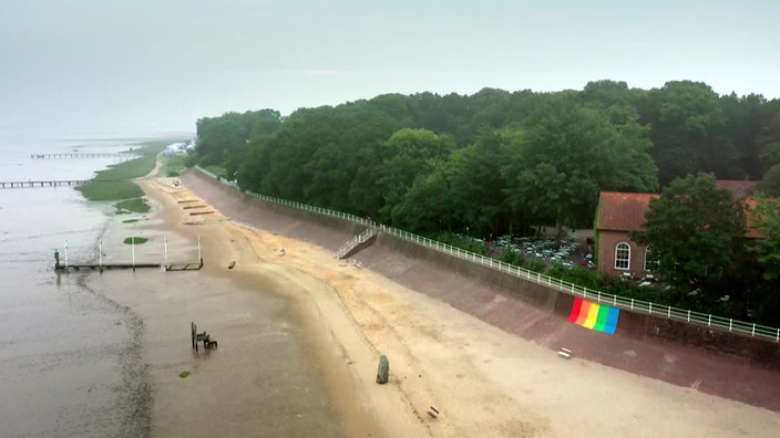 Kurpark Dangast mit vielen Bäumen oberhalb eines Sandstrandes