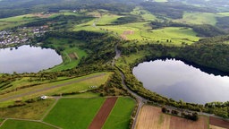 Luftaufnahme von zwei Eifelmaaren in grüner Wald-Wiesen-Landschaft