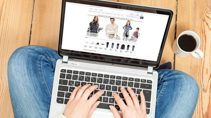 Auf einem aufgeklappten Notebook wird ein Onlineshop angeschaut