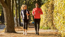 Das Bild zeigt einen Mann und eine Frau, die joggen. 