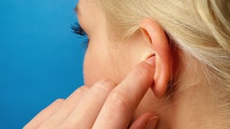 Das Bild zeigt eine Frau mit Tinnitus.