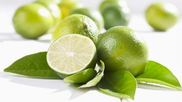 Mehrere Limetten und eine aufgeschnittene Limette