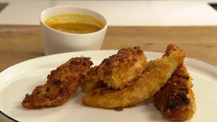 Das Bild zeigt Chicken Nuggets, serviert auf einem weißem Teller.