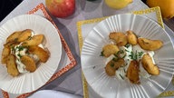 Karamelläpfel mit Frischkäse auf zwei Tellern angerichtet