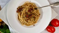Pasta mit Steinpilzsugo in einem tiefen Teller angerichtet