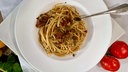 Pasta mit Steinpilzsugo in einem tiefen Teller angerichtet