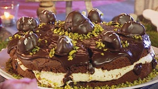 Torte mit dunklen Kugeln und Pistazien verziert