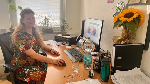 Die Sozialarbeiterin Saskia Lütgerhorst sitzt an ihrem Arbeitsplatz. Auf dem Computer sind Statistiken geöffent.