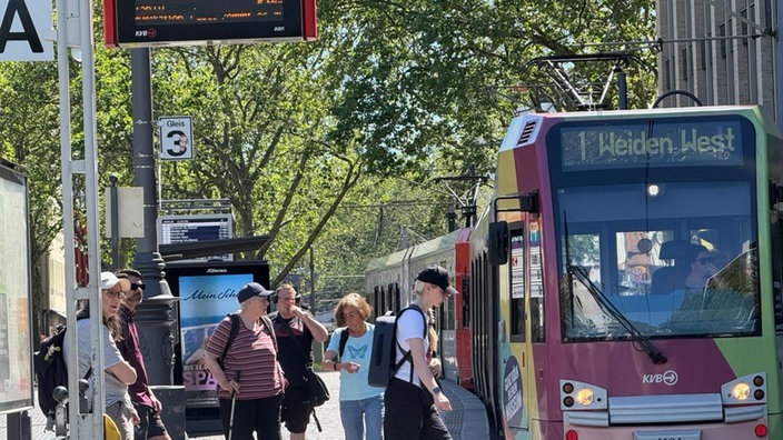 Eine Bahn fährt über eine große Straßenkreuzung in Köln.