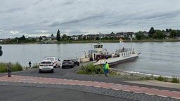 Autos werden auf eine Rheinfähre verladen