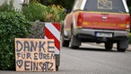 Ein Fahrzeug der Feuerwehr fährt an einem Schild mit der Aufschrift "Danke für Euren Einsatz" beim Waldbrand im Hürtgenwald vorbei. Mehrere Hundert Hektar Waldfläche stehen in Flammen.
