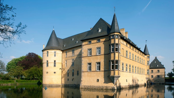 Die Wasserburg Adendorf spiegelt sich im Wasser des Burggrabens