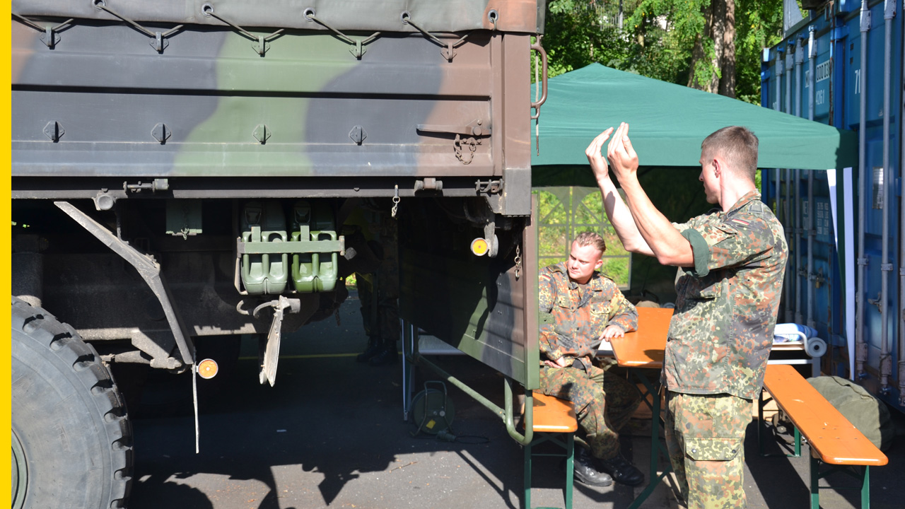 Bundeswehr bei Hilfsarbeiten, zwei Soldaten navigieren Lkw