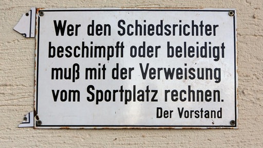 Schild mit der Aufschrift "Wer den Schiedsrichter beschimpft oder beleidigt muß mit Verweisung vom Sportplatz rechnen" pixel!